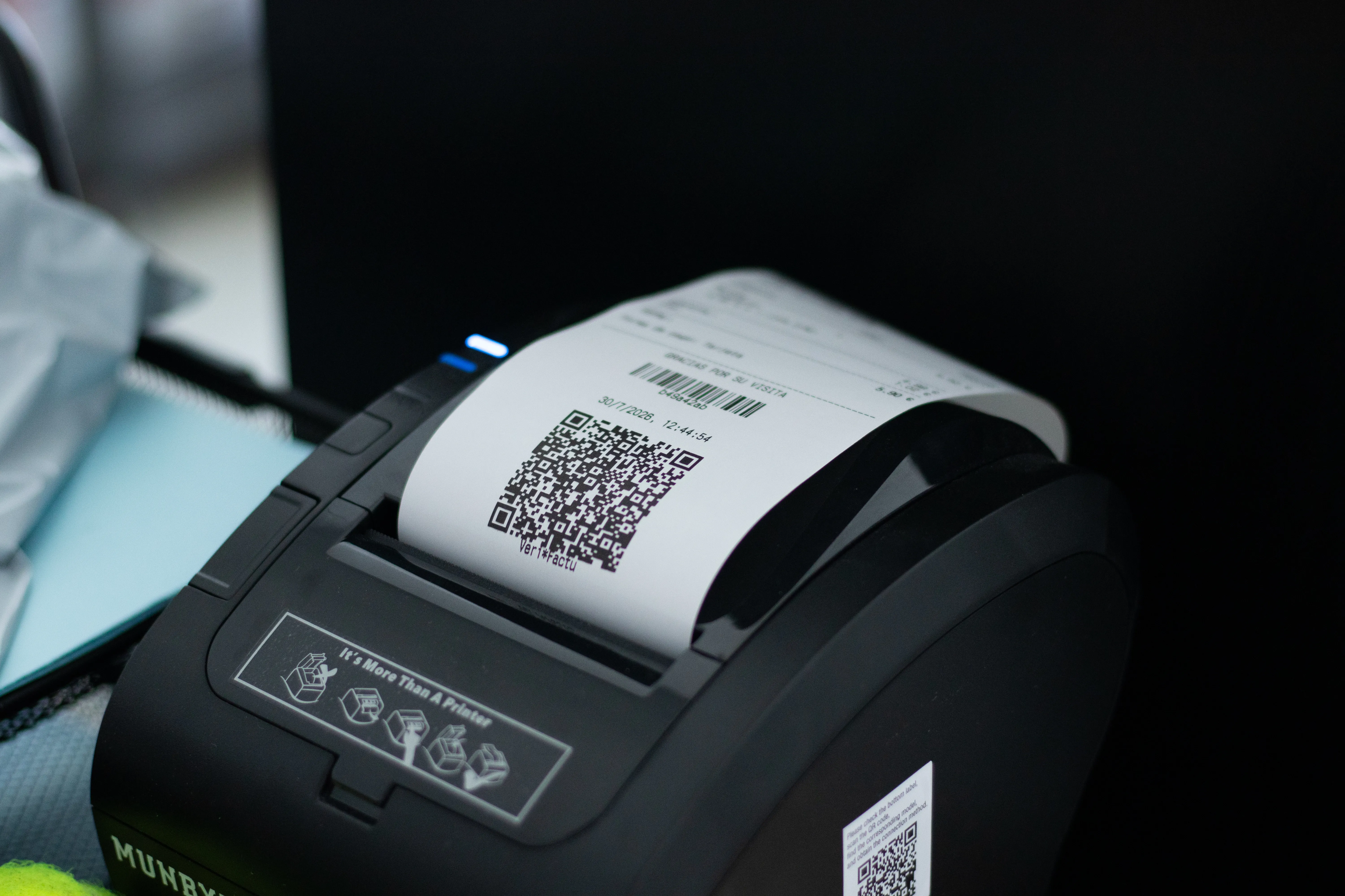 Impresora de tickets imprimiendo un ticket de NERO con su código QR VeriFactu